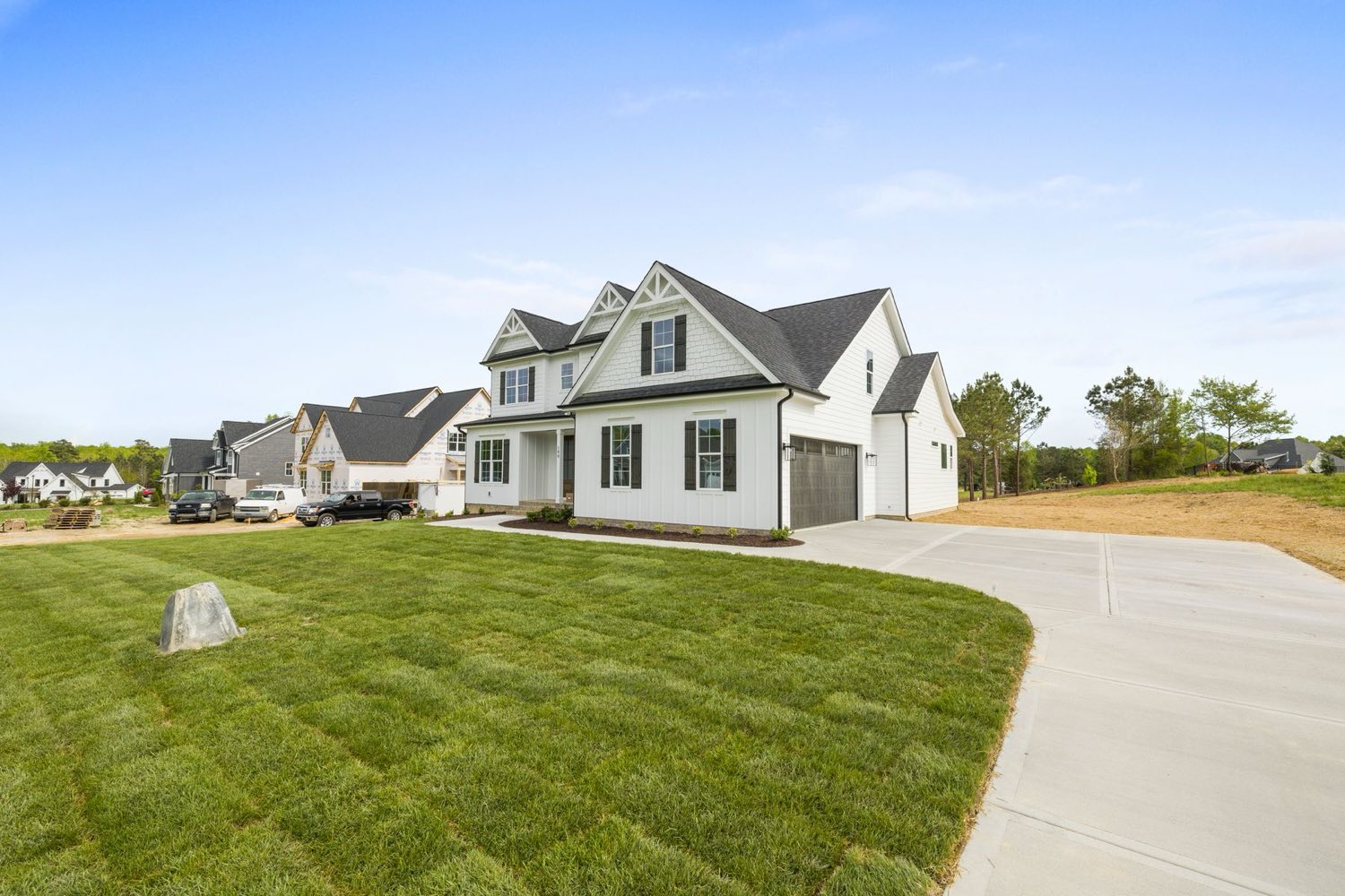 New house on the exurban edge with fresh sod and open ground behind it